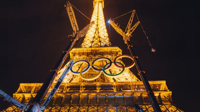 Paris 2024 के उद्घाटन समारोह से पहले Olympics रंगों में जगमगाया Eiffel Tower